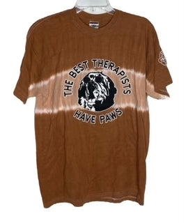 Brown "The Best Therapists Have Paws" T-shirt featuring a black and white graphic of a dog's face with textual design, displayed on a hanger.