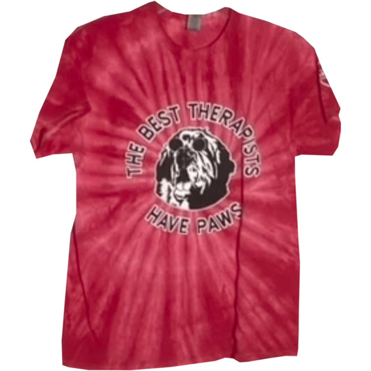 Red tie-dye t-shirt featuring the phrase "THE BEST THERAPISTS HAVE PAWS" in a circular black and white graphic with a paw print and dog silhouette.